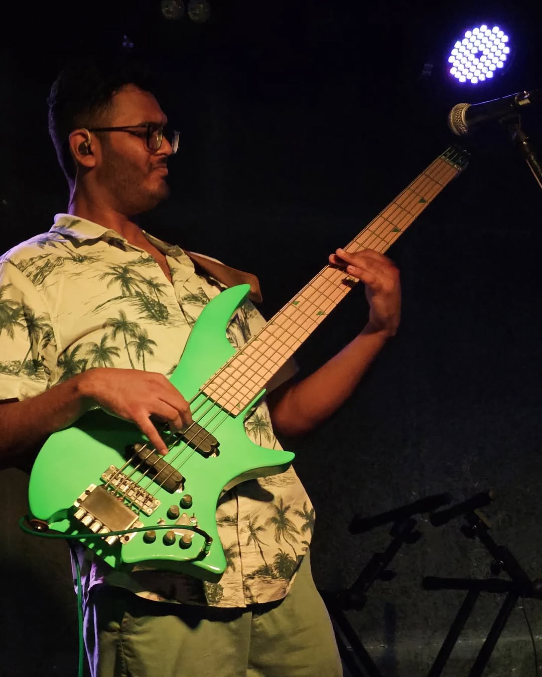 Photo of Anirudh MV looking cool while playing the bass on stage.